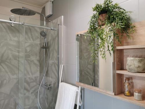 La salle de bains est pourvue d'une douche murale avec des plantes. dans l'établissement Le Bois aux Cerfs, à Bois-Jérôme-Saint-Ouen