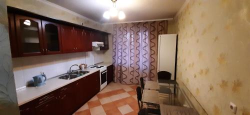 uma pequena cozinha com um lavatório e um fogão em Уютная квартира em Kiev