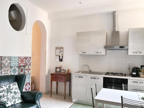 a kitchen with white cabinets and a table and a dining room at Casa 28 in Bologna