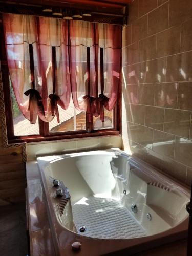 eine Badewanne im Bad mit Fenster in der Unterkunft Cabaña Sol in Mazamitla