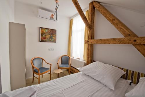 sypialnia z łóżkiem i 2 krzesłami w obiekcie Salon Win Wine Bar & Apartments w mieście Jasło