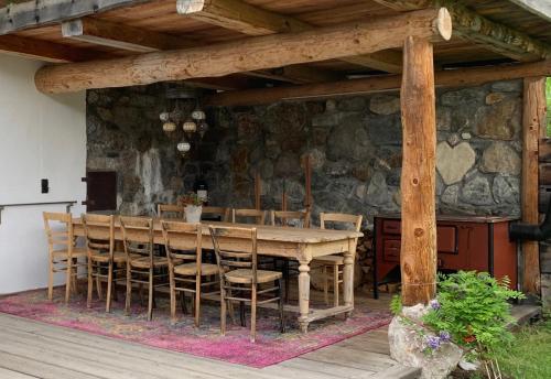 a wooden table with chairs and a stone wall at Ferienhaus Krieben 