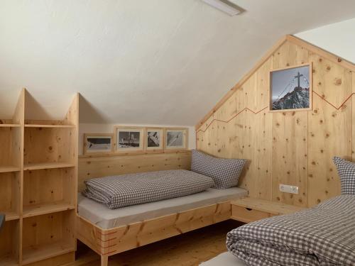 - 2 lits dans une chambre dotée de murs en bois dans l'établissement Ferienhaus Krieben, 