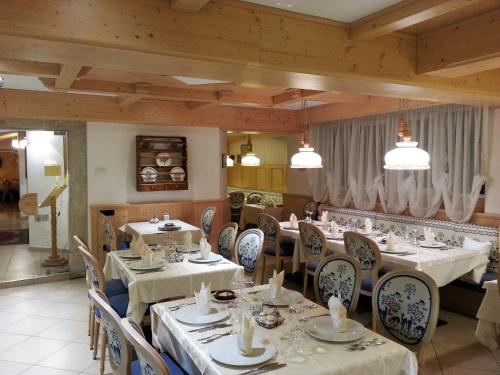 un restaurante con mesas y sillas en una habitación en Folgaria Post Hotel, en Folgaria