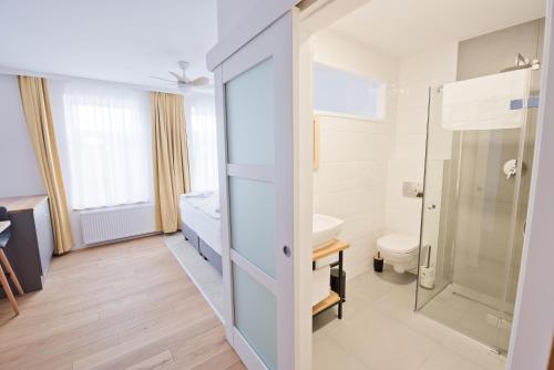 a bathroom with a shower and a toilet at Salon Win Wine Bar & Apartments in Jasło