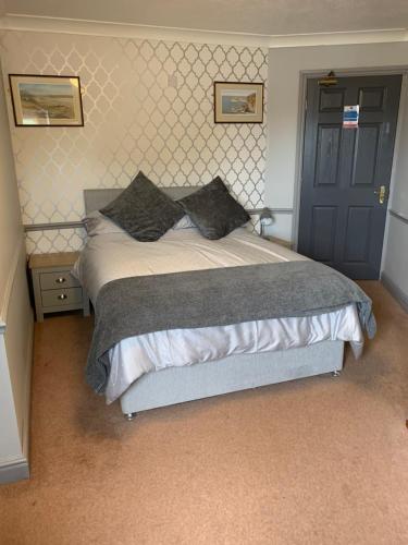 a bedroom with a large bed and a blue door at Tafarn Y Rhos in Llangefni