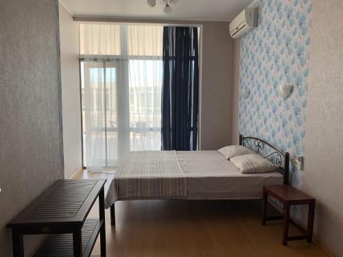 a bedroom with a bed and a large window at Town-house Golden Bugaz in Karolino-Buhaz