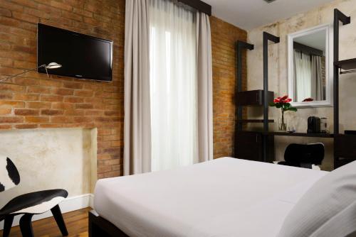 a bedroom with a bed and a tv on a brick wall at Relais Orso in Rome