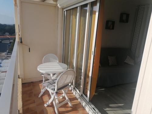 d'un balcon avec deux chaises et une table. dans l'établissement Appartement avec vue superbe sur le port, à Saint-Cyprien