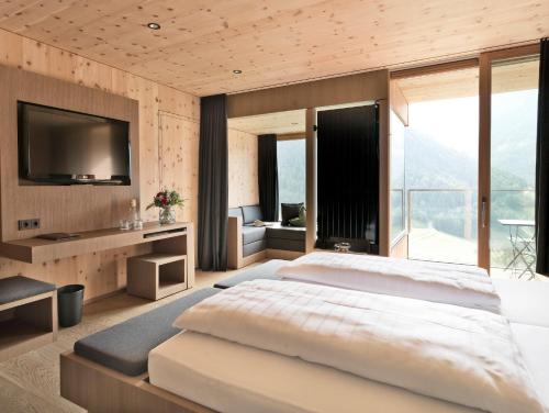 カルス・アム・グロースグロックナーにあるGradonna Mountain Resort Chalets & Hotelの大きなベッドとテレビのある寝室