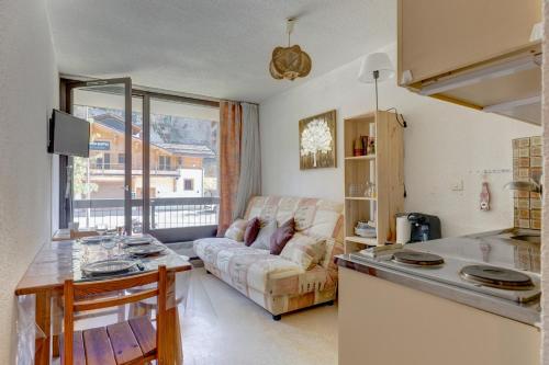 une cuisine et un salon avec un canapé dans l'établissement Le Calao - appartement au Val d'Arly, à Flumet