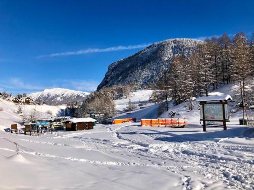 a snow covered slope with a mountain in the background at Hotel Piccolo Chalet in Claviere