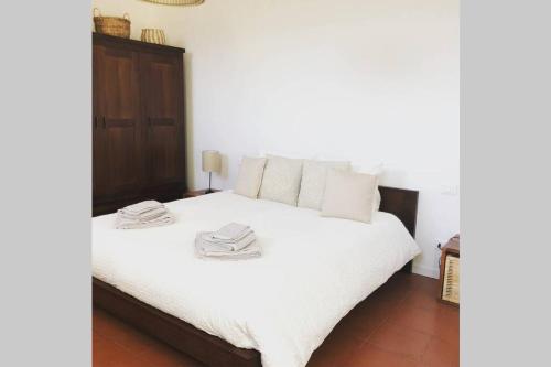 - une chambre avec un lit blanc et une tête de lit en bois dans l'établissement "Come una Volta" Charme & Relax in citta' alta, à Bergame