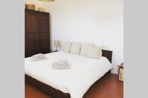 Un dormitorio con una cama blanca con cabecero de madera. en "Come una Volta" Charme&Relax in citta' alta, en Bérgamo