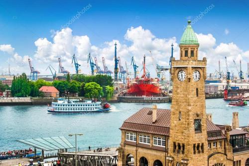 a clock tower with a cruise ship in the harbor at Hotel Am Stadtpark in Buxtehude
