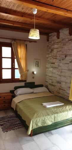 a bedroom with two beds and a brick wall at EVI Studios & Apartments in Naxos Chora