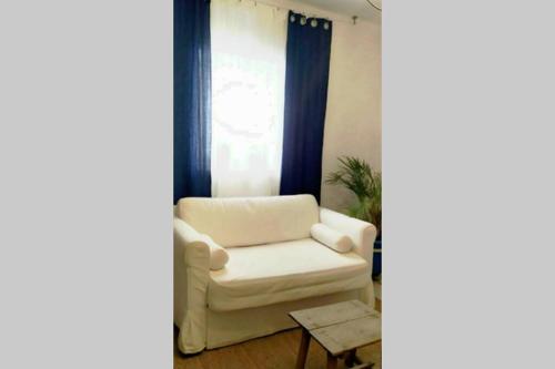 a living room with a white chair and a window at La musa del Poeta in Quesada