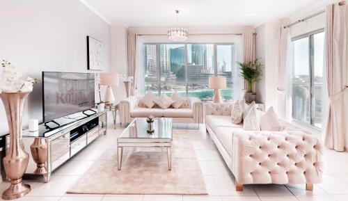 uma sala de estar com móveis brancos e uma grande janela em Elite Royal Apartment - Full Burj Khalifa & Fountain View - Brilliant - 2 bedrooms & 1 open bedroom without partition no Dubai