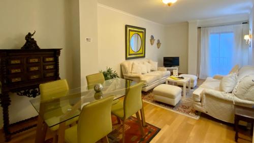 sala de estar con mesa de cristal y sillas amarillas en Downtown by Check-in Portugal, en Faro