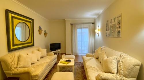 una sala de estar con 2 sofás blancos y un espejo en Downtown by Check-in Portugal, en Faro