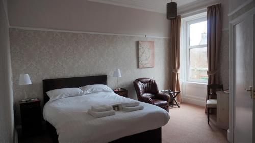 um quarto de hotel com uma cama com toalhas em Lindean Guest House em Dumfries