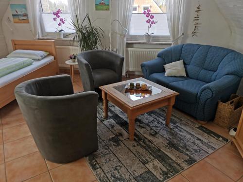 比德爾斯多夫的住宿－Ferienwohnung Stanke，客厅配有沙发、两把椅子和一张桌子