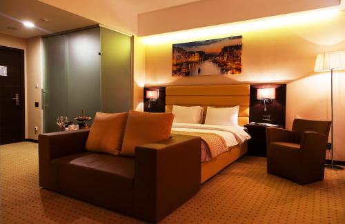 アスタナにあるComfort Hotel Astanaのベッドとソファ付きのホテルルーム