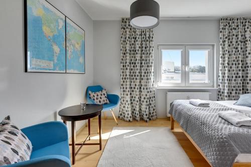 een slaapkamer met een bed, een tafel en een stoel bij Comfort Apartments Abrahama in Gdynia