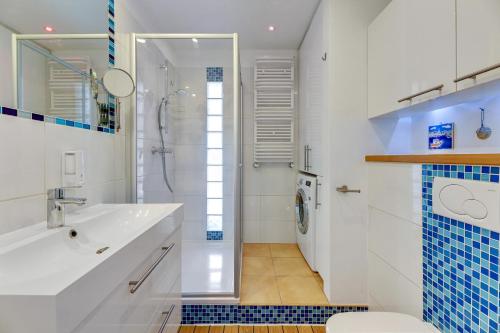 een badkamer met een wastafel, een douche en een toilet bij Comfort Apartments Abrahama in Gdynia