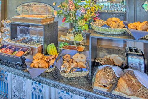 un buffet lleno de diferentes tipos de pan en Grandcafé Boutique Hotel Eemland, en Eemnes