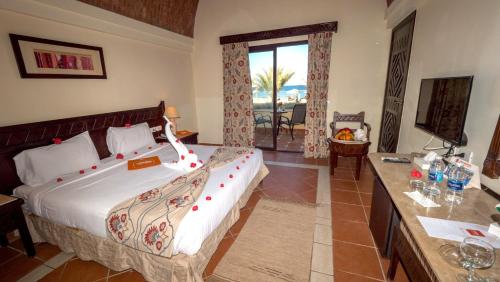 a hotel room with a large bed and a balcony at ONATTI Beach Resort - Adults Only 16 Years Plus in Quseir
