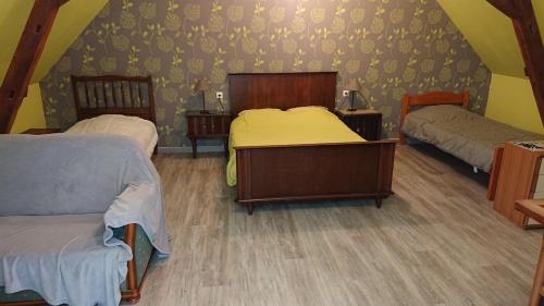 a bedroom with two beds in a attic at Les Chambres du Relais in Liettres