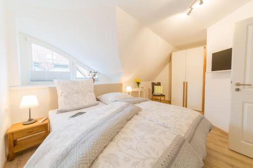 a bedroom with a large bed and a window at Haus Bugspriet Haegerende in Zingst