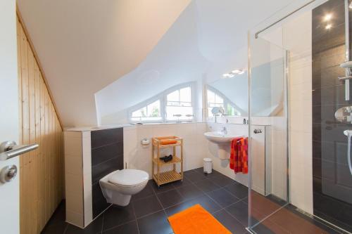 a bathroom with a toilet and a sink at Haus Bugspriet Haegerende in Zingst