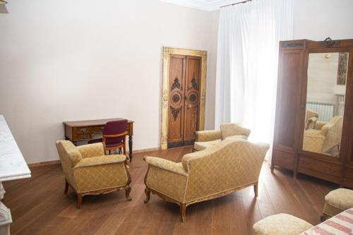 a living room with two chairs and a mirror at Hotel Tornielli 9 by LVG Hotel Collection in Novara