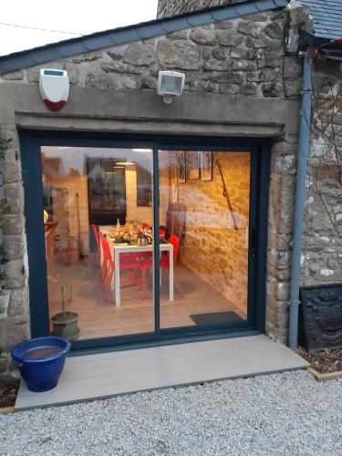 Une porte coulissante en verre s'ouvre sur une terrasse avec une table. dans l'établissement La Longère d'Arzoù, chambres d'hôtes, à Baden