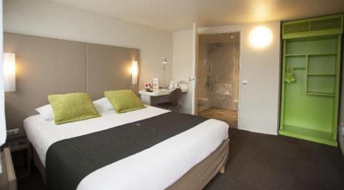 a bedroom with a large bed and a bathroom at Campanile Lille - Seclin in Seclin