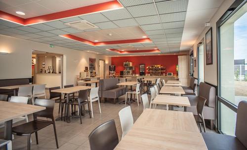 a restaurant with tables and chairs and a bar at Ace Hotel Annemasse Genève in Ville-la-Grand