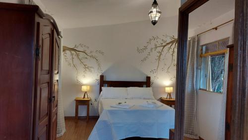 a bedroom with a bed with a blue blanket at Rancho da Serra Pousada in Tiradentes