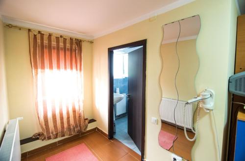 a bathroom with a door leading to a bathroom with a window at Casa Domneasca in Baia de Fier