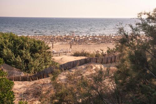 a beach with chairs and umbrellas and the ocean at Modica Boutique Hotel in Modica