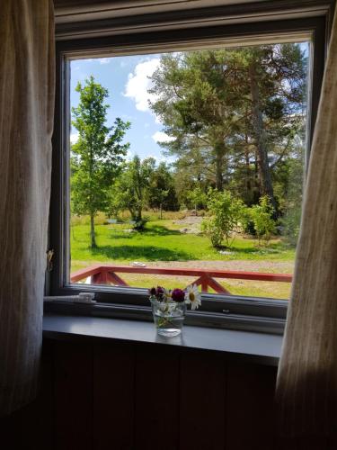 a window with a vase of flowers on a window sill at Södra Kärr 4 in Gränna