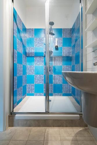 a blue tiled bathroom with a shower and a sink at Tui Beds in Arenzano