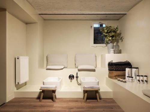 a bathroom with two sinks and two stools at Townhouse Maastricht & Spa in Maastricht