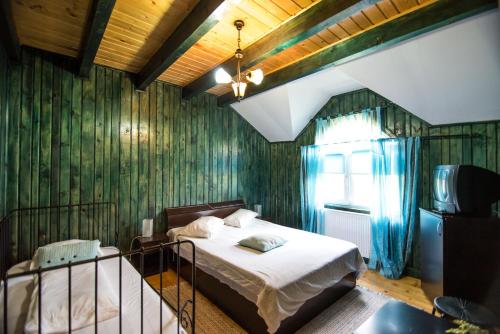 a bedroom with a bed in a room with green wallpaper at Casa Domneasca in Baia de Fier