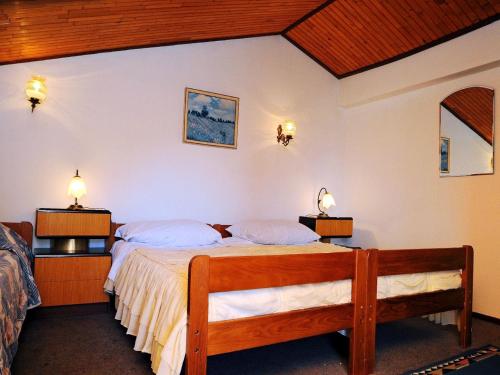 a bedroom with two beds and two lights on the wall at Apartments Mandica in Rabac