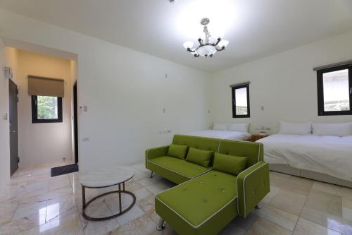 a living room with two beds and a green couch at 七星潭118海景民宿 in Dahan