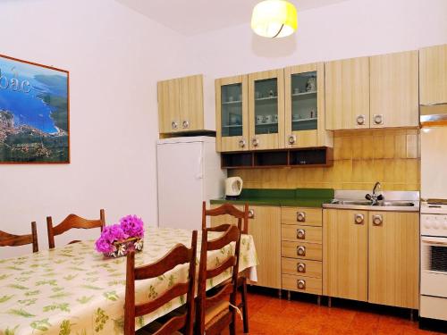 a kitchen with a table with purple flowers on it at Apartments Mandica in Rabac