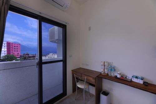 a room with a desk and a large window at 七星潭118海景民宿 in Dahan