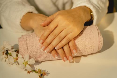 a woman holding her hands on a towel at H Hotel & SPA - Adults Only in St Julian's